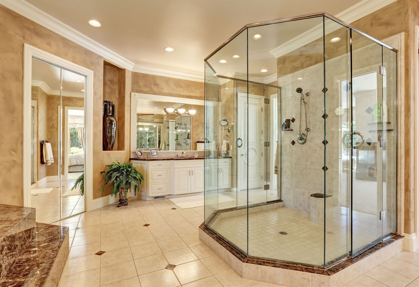 Beautiful luxury marble bathroom interior in beige color. Large glass walk in shower.