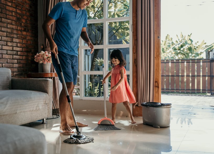 a dad is cleaning with his daughter