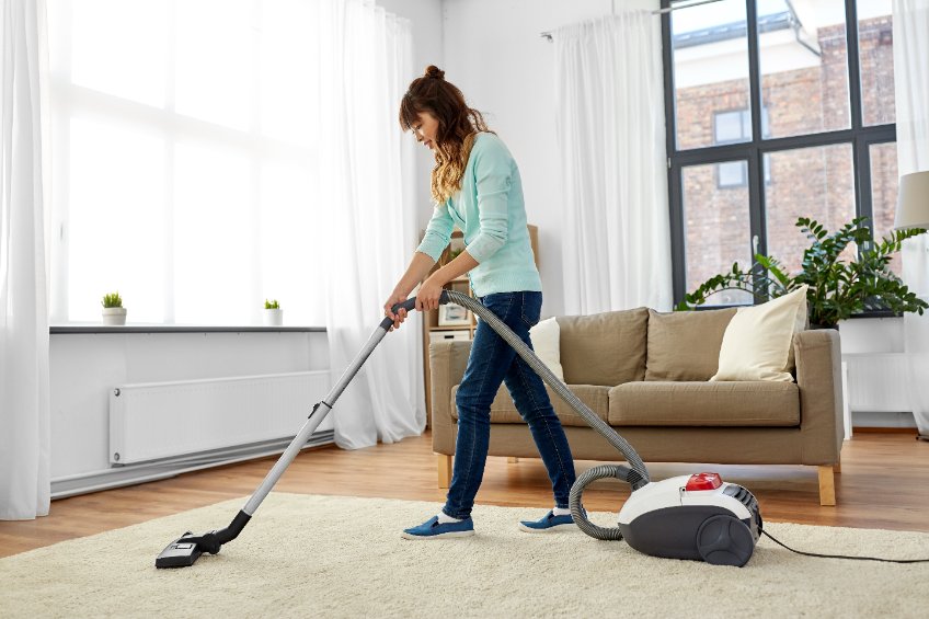 a woman is cleaning an area rug